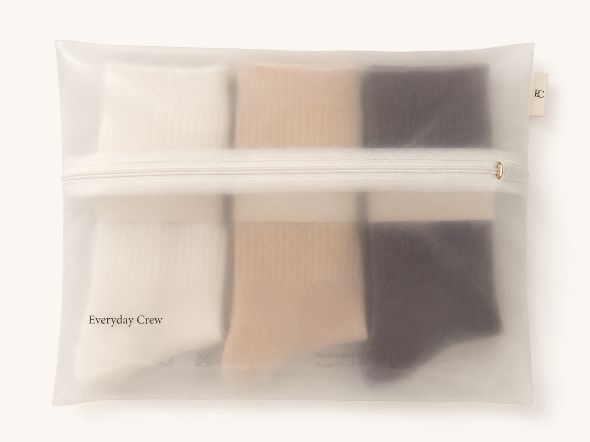The Natural Set packed flat in its cream mesh wash bag with a gold zipper